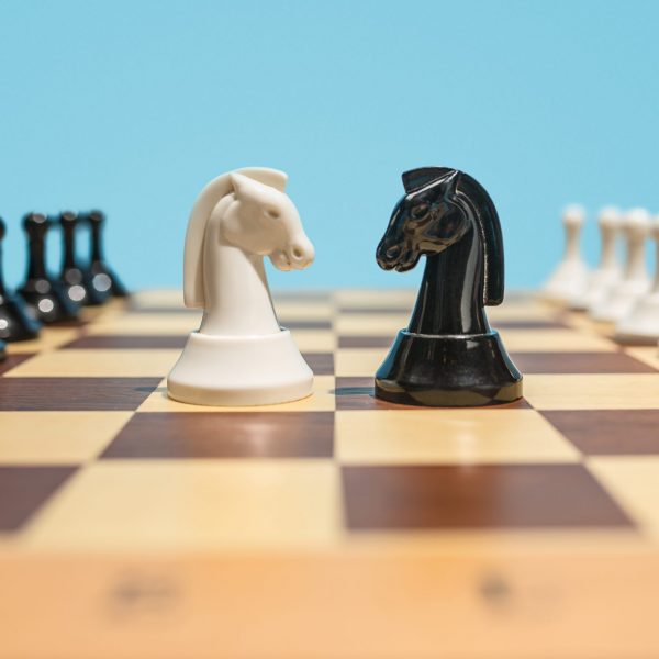 Struggle and confrontation. Chess board and game concept. Business ideas, competition, strategy and new ideas concept. Chess figures on blue background. Selective focus. Side view. Win, victory, winner concepts